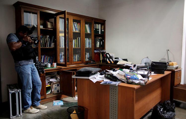 A local photographer makes a video of journalist Carlos Fernando Chamorro's office the day after it was raided by the national police in Managua, Nicaragua. (REUTERS/Oswaldo Rivas)